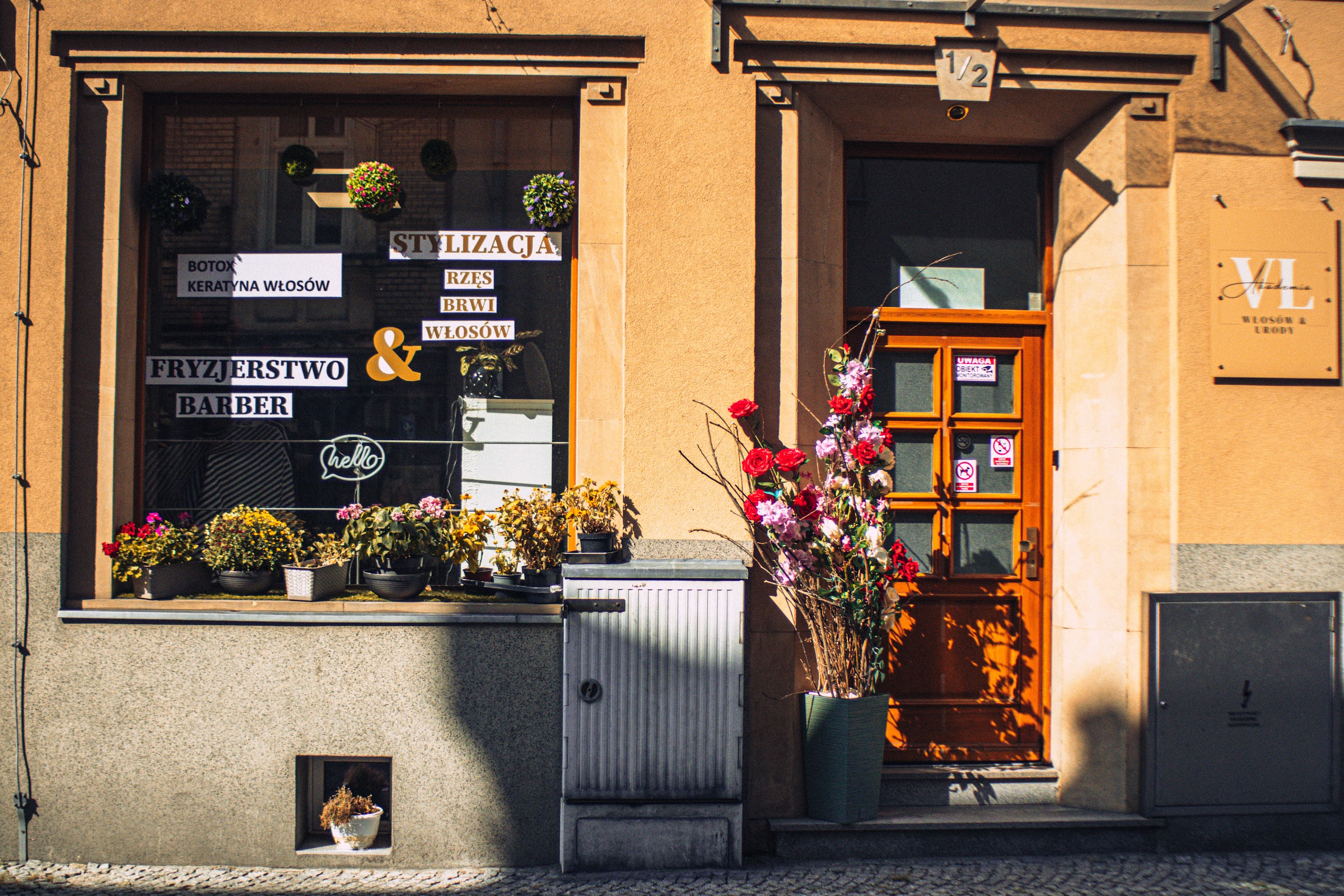 Witryna Akademii Włosów i Urody z napisami Fryzjerstwo, Barber, Stylizacja rzęs, brwi i włosów